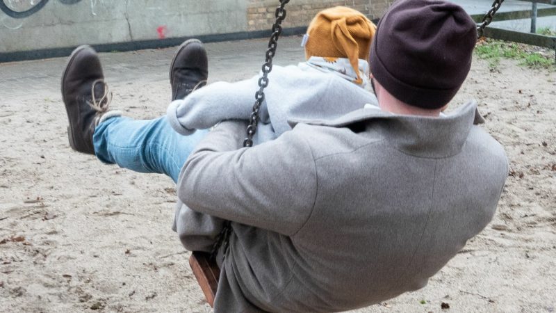 Ein Vater mit seinem Kind auf einem Spielplatz: Paare sollen zwar weiterhin zusammen bis zu 14 Monate Elternzeit nehmen können - aber nur noch maximal einen Monat parallel.